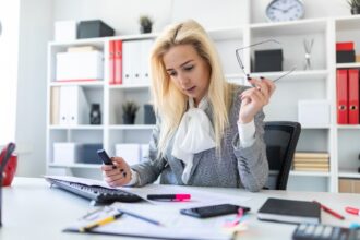 Młoda dziewczyna w biurze pracuje z markierem i dokumentami.