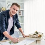 Portret architekta projektanta siedzi przy biurku w biurze burza mózgów pomysł na projekt architektoniczny pracujący nad szkicem planu Namiętna i innowacyjna kreatywność w architekturze Iteracja