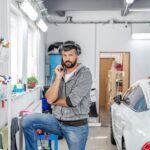 Mechanik telefonujący w garażu do ręcznego mycia i czyszczenia samochodów